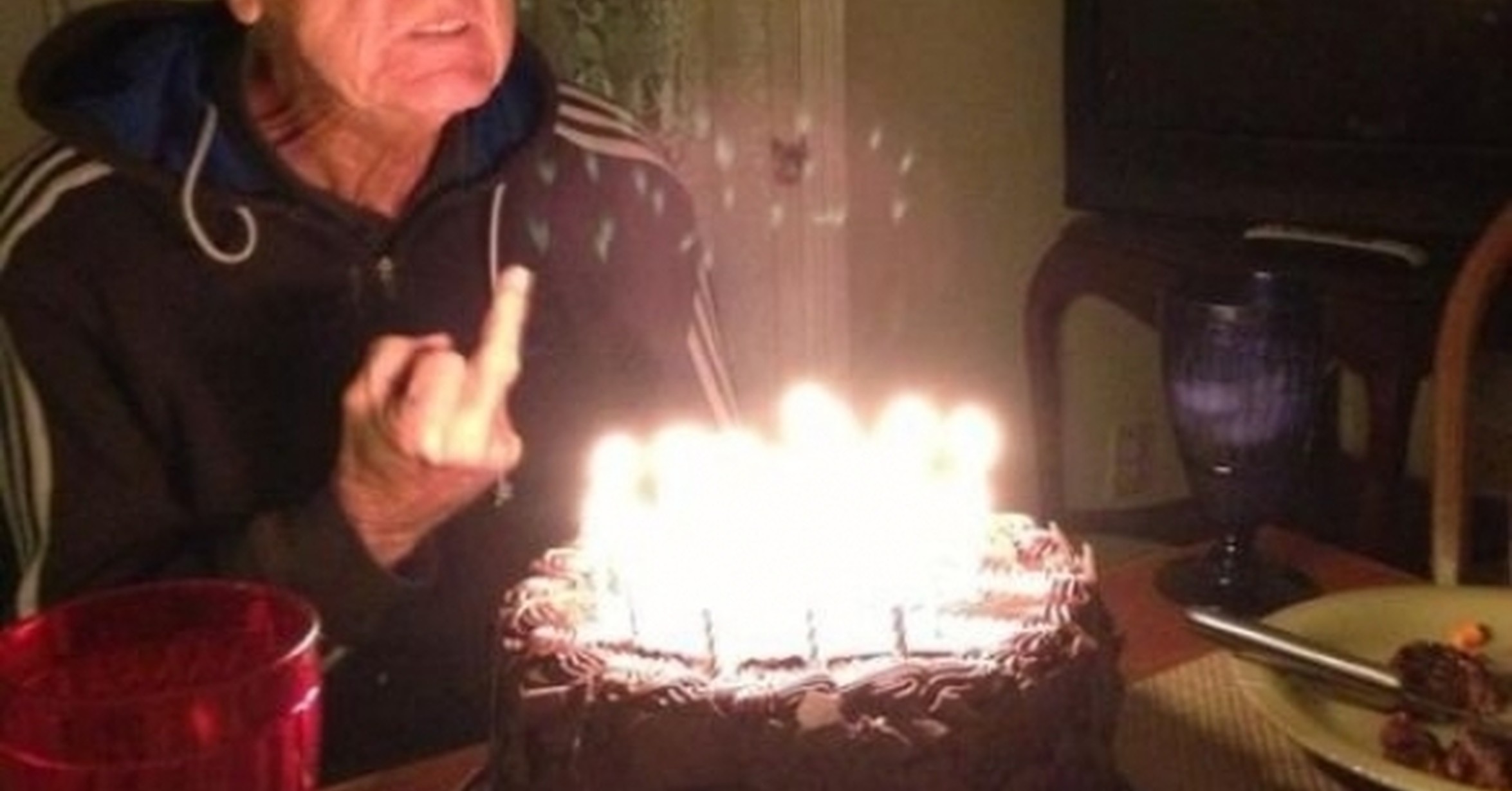 Дед задувает свечи на торте