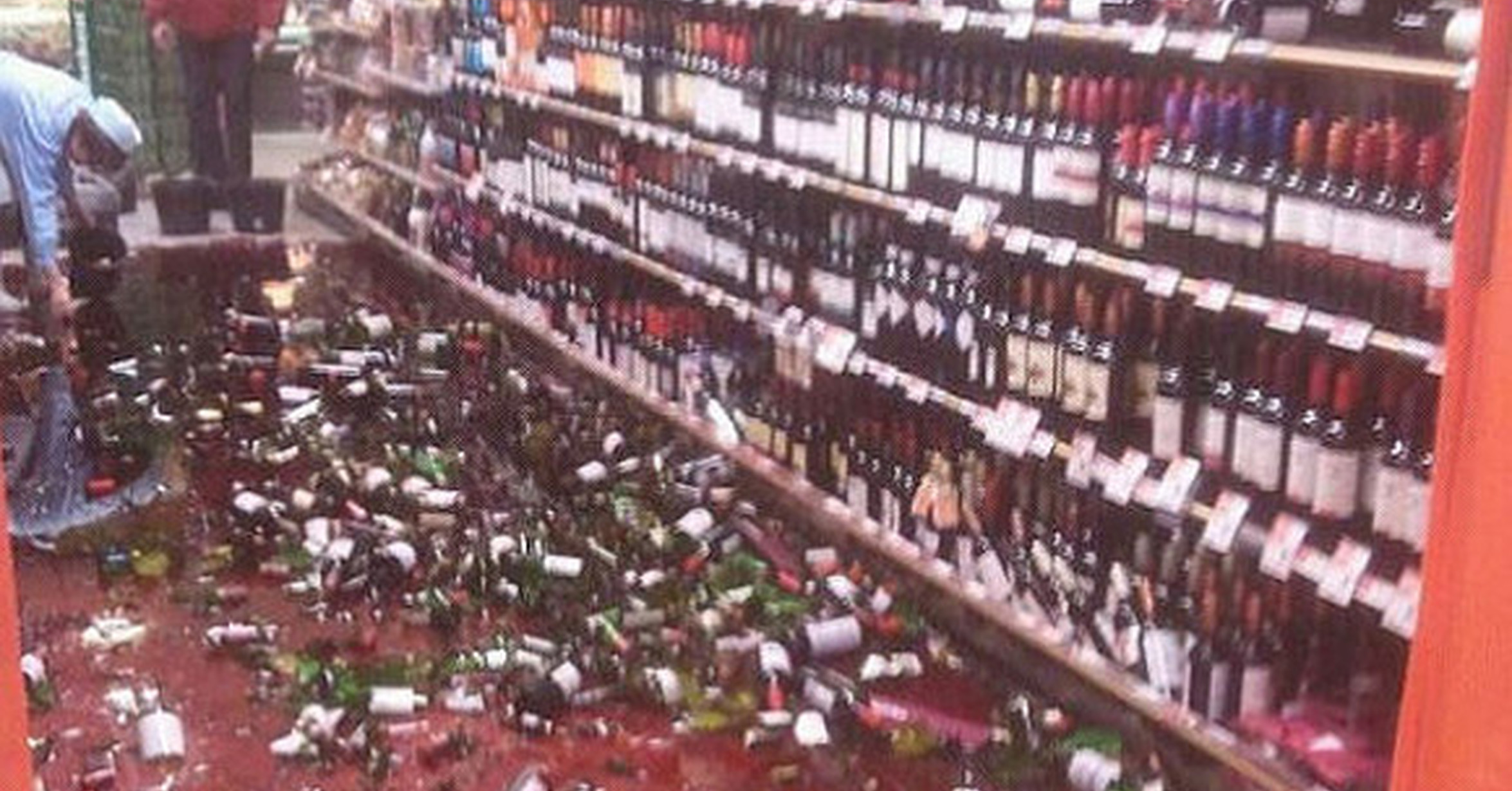 Разбитые бутылки в магазине. Разбитые бутылки вина в магазине.