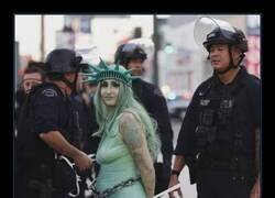 Enlace a Agentes del Departamento de Policía de Los Ángeles arrestan a una manifestante disfrazada de la Estatua de la Libertad durante la protesta 