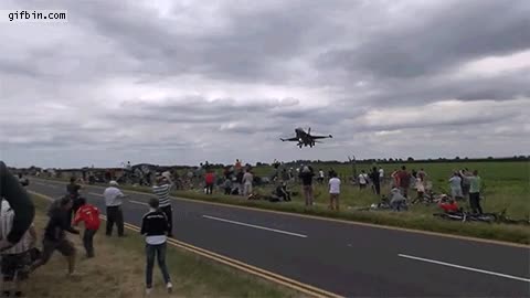 Un F-16 haciendo un vuelo que no sé si podría ser más rasante por encima de los espectadores f-16,avion de combate,volar,vuelo,rasante,a ras,piloto,exhibicion