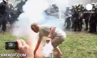 agentes,policía,manifestación,antidisturbios,bote,humo,devolver