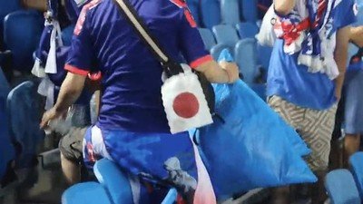 Enlace a Aficionados japoneses limpiando las gradas después del partido