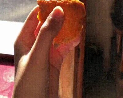 Enlace a Apretando la piel de una naranja en cámara lenta