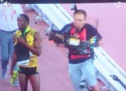 Enlace a GIF: Un cámara atropella a Usain Bolt mientras celebra y lo tira por los suelos