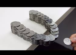 Enlace a Logran equilibrar un montón de monedas sin necesidad de pegamento