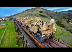 Enlace a Un drone sigue a un tren cargado de vehículos militares