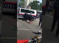 Enlace a Policía austriaca detiene a una persona ante abucheos y está a punto de atropellarle la cabeza al detenido