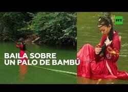 Enlace a Bailando sobre una caña de bambú en un río