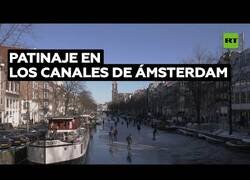 Enlace a Ciudadanos de Ámsterdam patinan por los canales helados de la ciudad