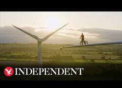 Enlace a Biker profesional se pasea por el aspa de un molino eólico