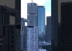 Enlace a Un avión vuela entre los edificios de una ciudad en Australia