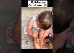 Enlace a Niña le pinta las uñas a una gallina