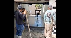 Enlace a Mujer pasa por el cemento recién puesto ante la mirada de los obreros