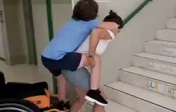 Esta madre tiene que subir a su hijo a cuestas porque el ascensor del colegio está averiado