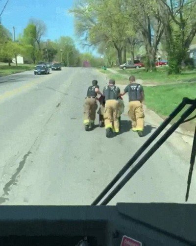 Enlace a Un grupo de bomberos empujando la silla de ruedas de un veterano de guerra
