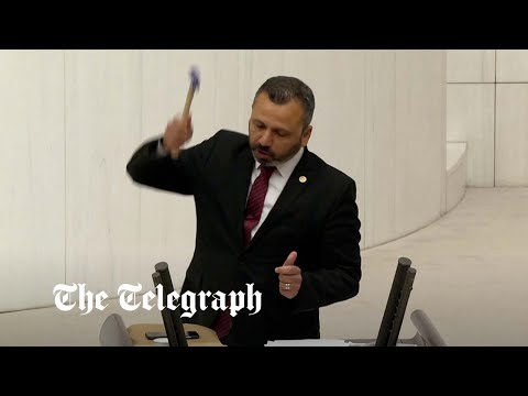 Legislador turco martillea su teléfono móvil durante una intervención