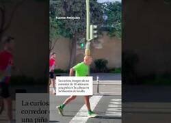 Enlace a Un hombre corre la Maratón de Sevilla con una piña en la cabeza
