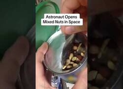 Enlace a Astronauta abre una lata de frutos secos en el espacio
