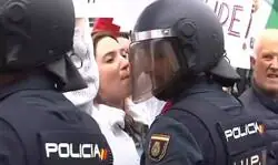 La sonrisa del polic&iacute;a ante la protesta de esta chica a pocos cent&iacute;metros de ella
